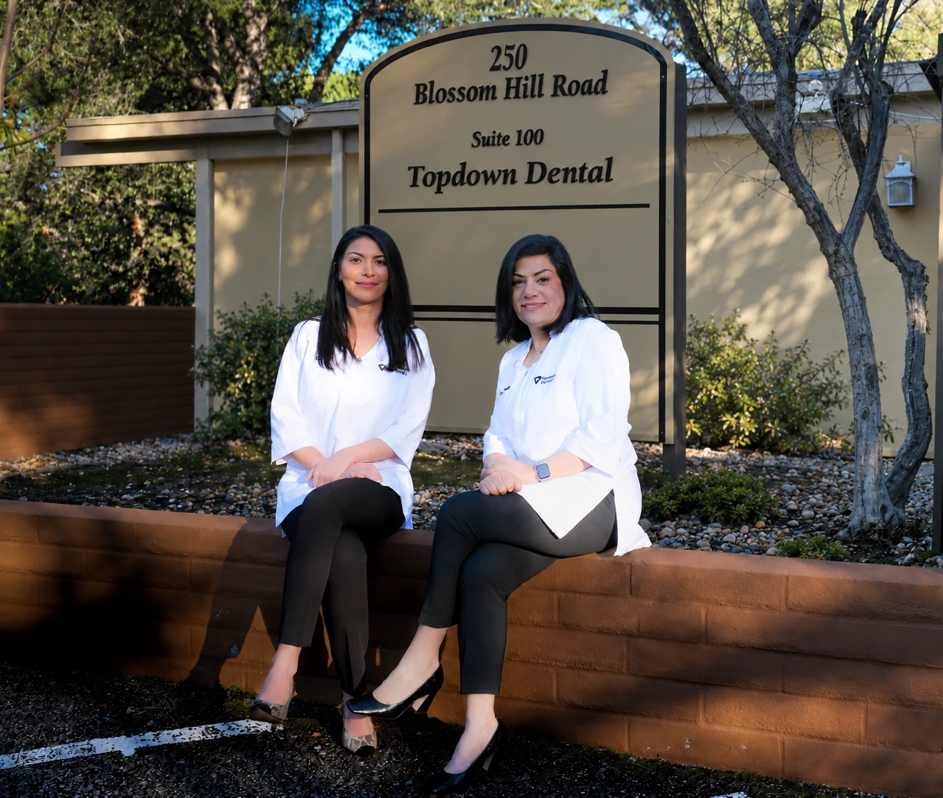 Dr. Rana Alan and Dr. Nancy Nehawandian outside Top Down Dental in front of the practice sign