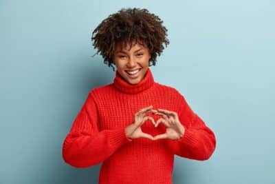woman making a heart with her hands over her own heart