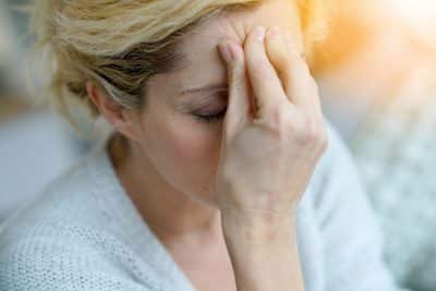mature woman holding her head in pain