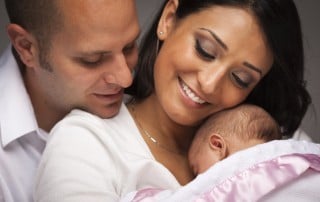 Man and woman hold their new born baby