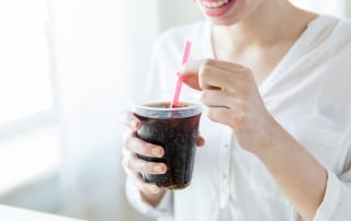 young woman prepares to drink a coke through a straw