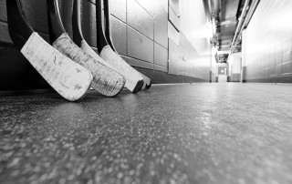 A set of hockey sticks rests up against a wall after a playoff game. While everyone loves a good hockey fight, have you ever thought about what happens when I player has their teeth knocked out?