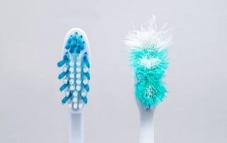 Two toothbrushes next to each other, one new and another very used. Researchers at Queen’s University Belfast conducted a study that suggests a link between poor oral health and an increased risk of liver cancer, yet another study that suggests your oral health impacts your health beyond just your mouth.