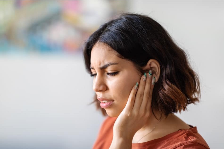 woman holding jaw in discomfort