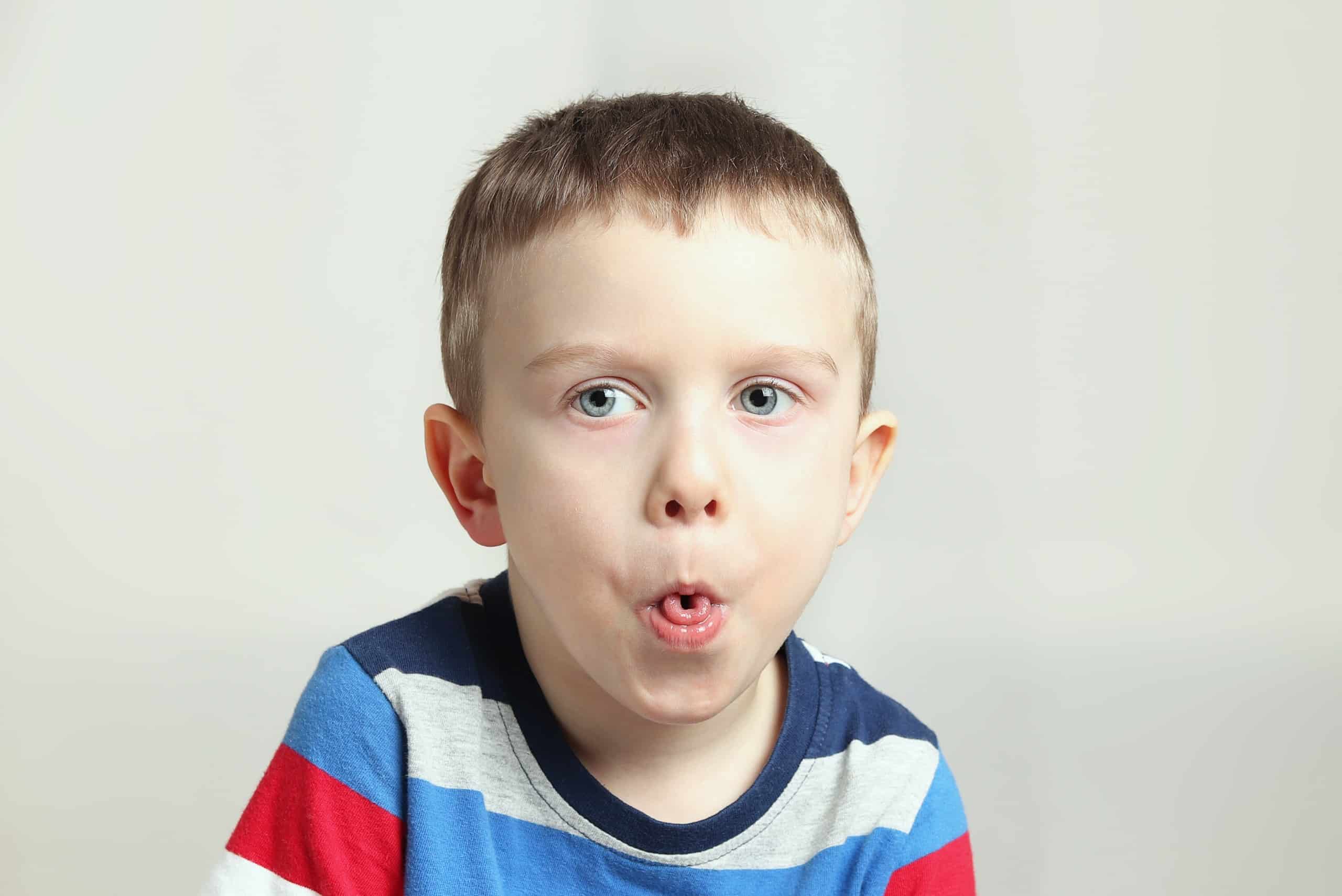 Boy, kid performs articulation exercises for the tongue, correct pronunciation, vocals, dental concept, speech therapy boy performs articulation tongue exercise