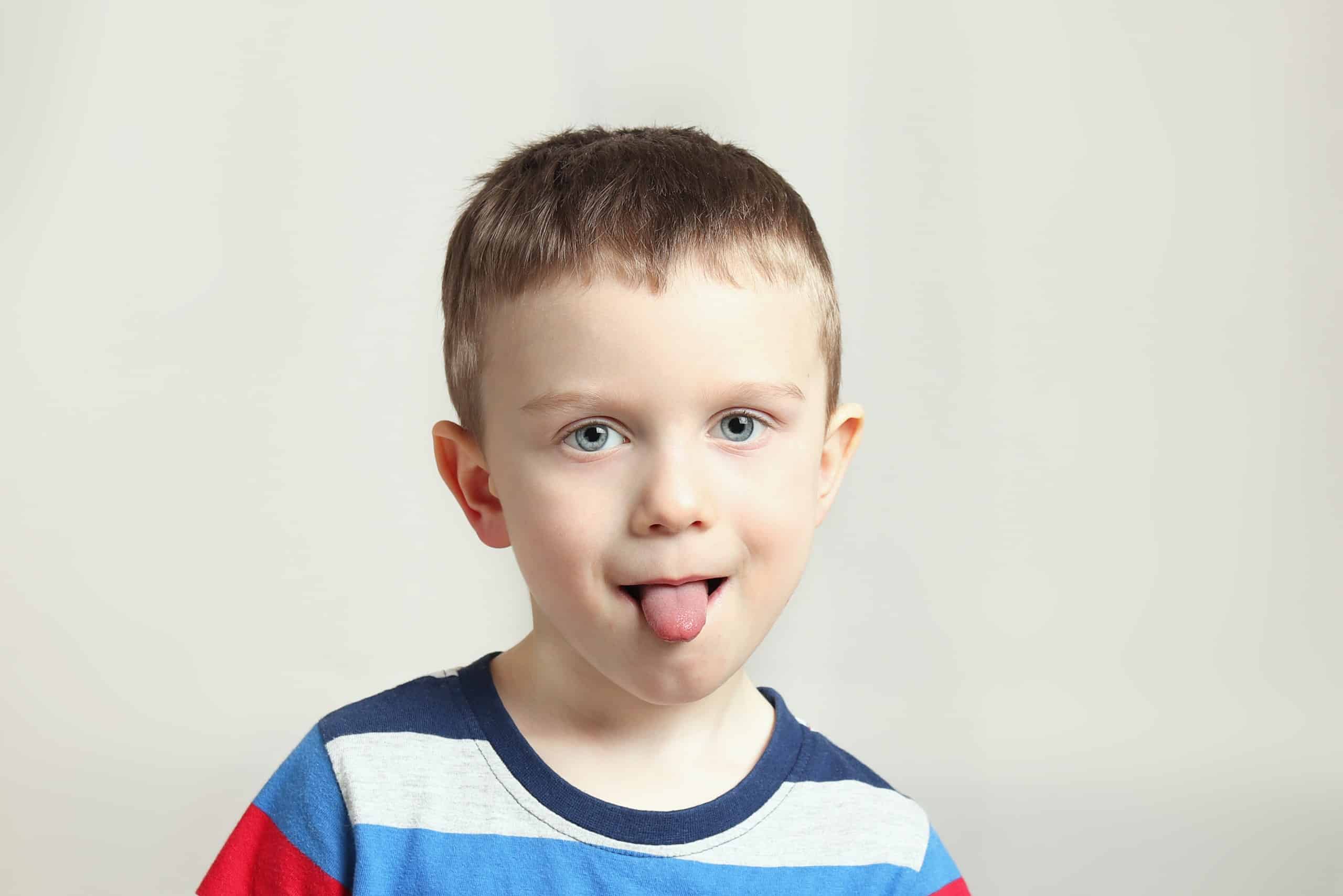 Boy, kid performs articulation exercises for the tongue, correct pronunciation, vocals, dental concept, speech therapy boy performs articulation tongue exercises